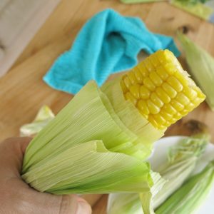 Microwave Corn on the Cob being pulled from husk